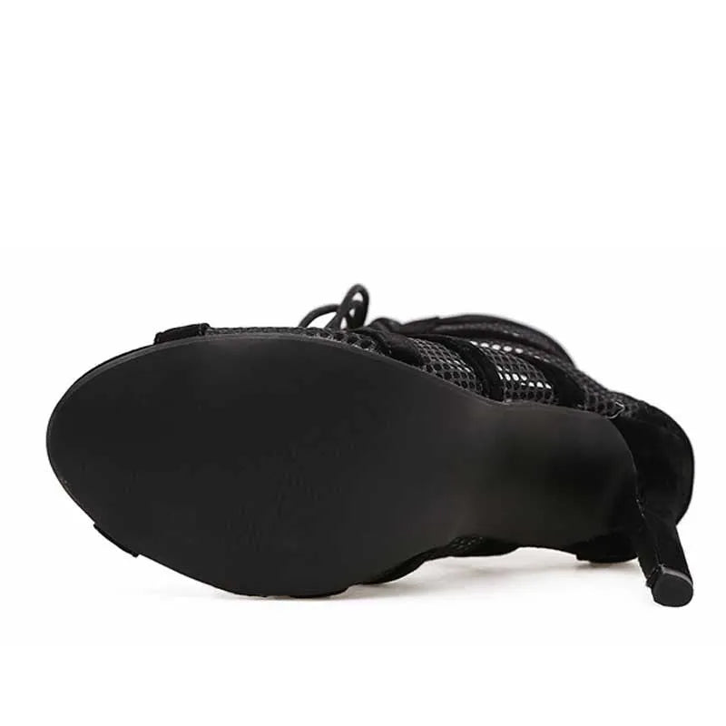 Black suede women's lace-up high heel shoes with a tall heel on a white background.