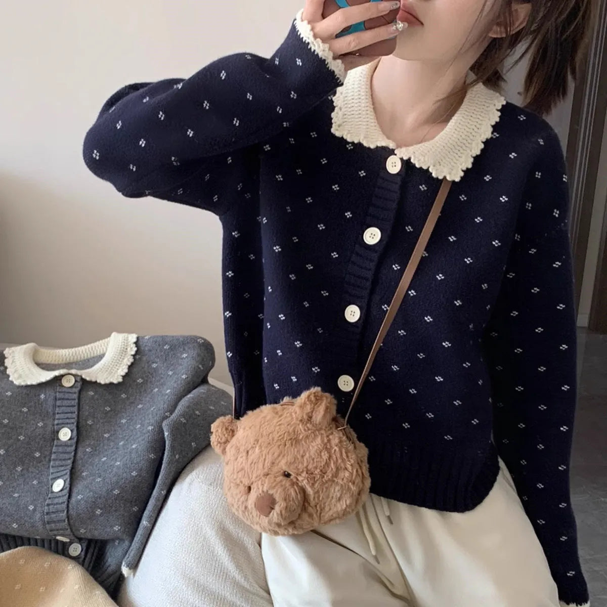 Navy blue floral patterned knitted cardigan coat with a white Peter Pan collar and button front.