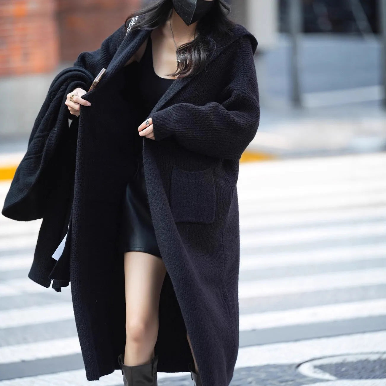 Long grey knitted hooded cardigan coat with trench coat styling on a model.