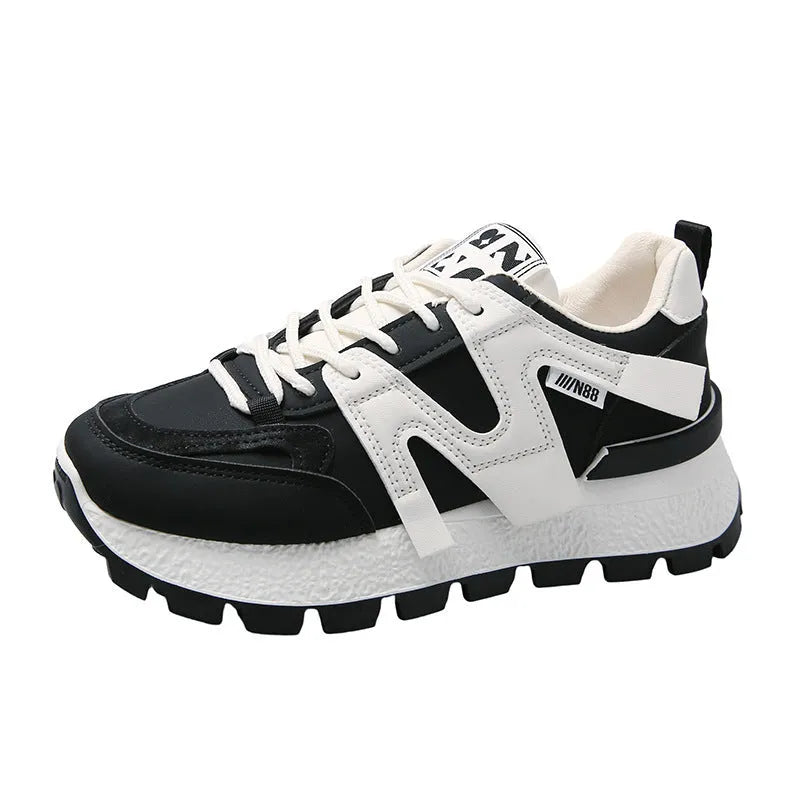 Low-top round-toe sneaker in black or white with lace-up front and flat rubber sole.