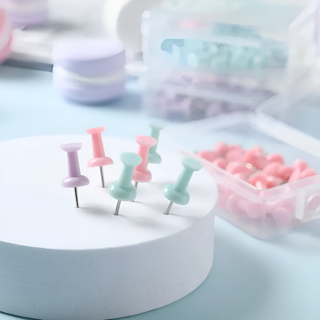 Plastic push pins in macaron colours: cherry blossom pink, mint green and lavender, displayed in small boxes.