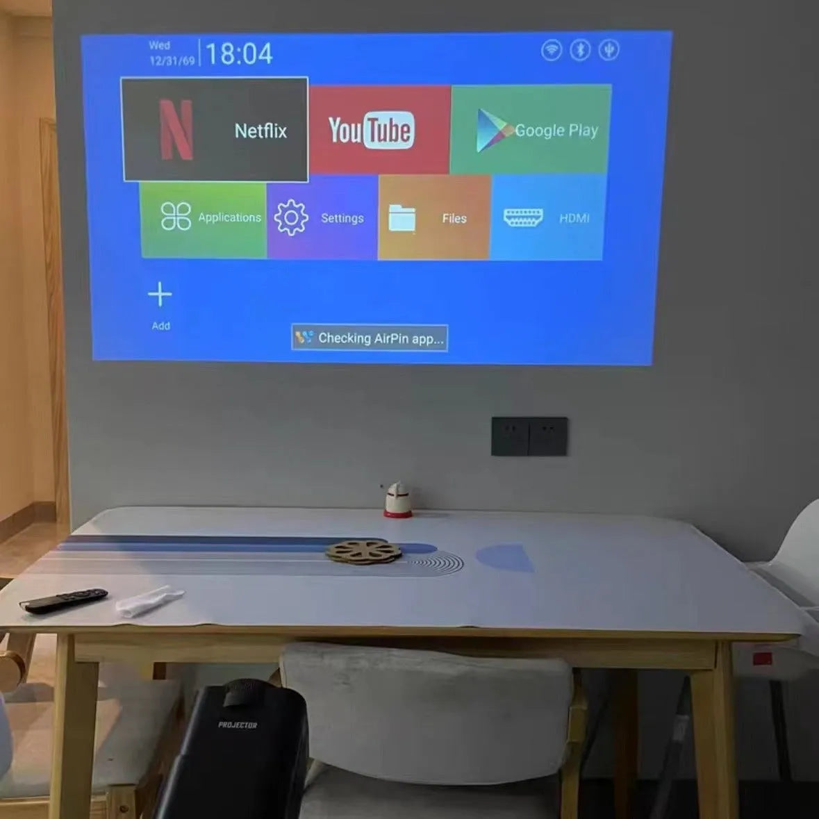 Wireless home gaming projector with HD 720p resolution displayed alongside gaming console