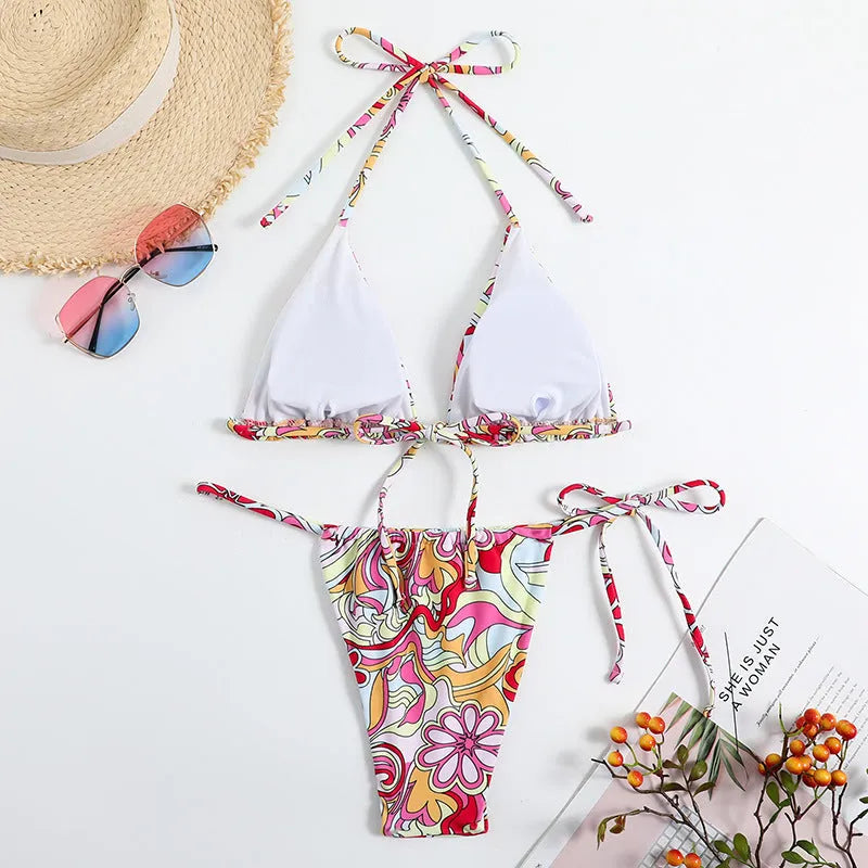 Women's multicolour triangle printed bikini with halter neck top and separate bottoms.