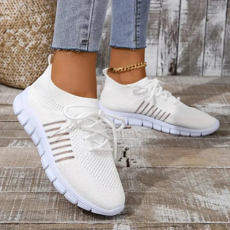 Women's breathable flying knit sports flats in beige with mesh upper and front lace tie.