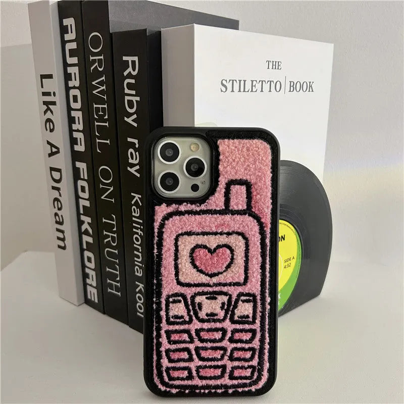 Pink iPhone case with a textured, towel-like embroidered design on the back.