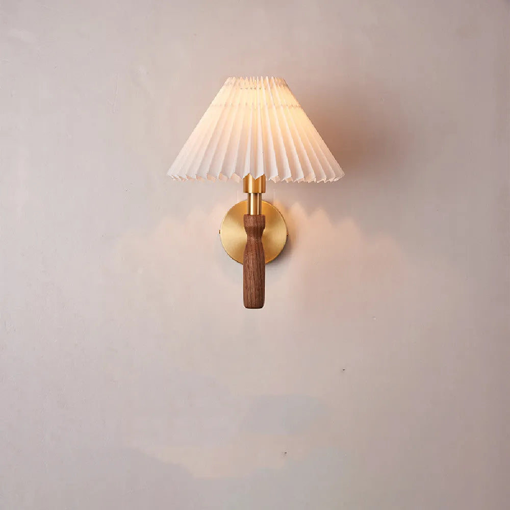 American Retro style wooden wall lamp with copper accents and a white fabric shade mounted above a bedside table.