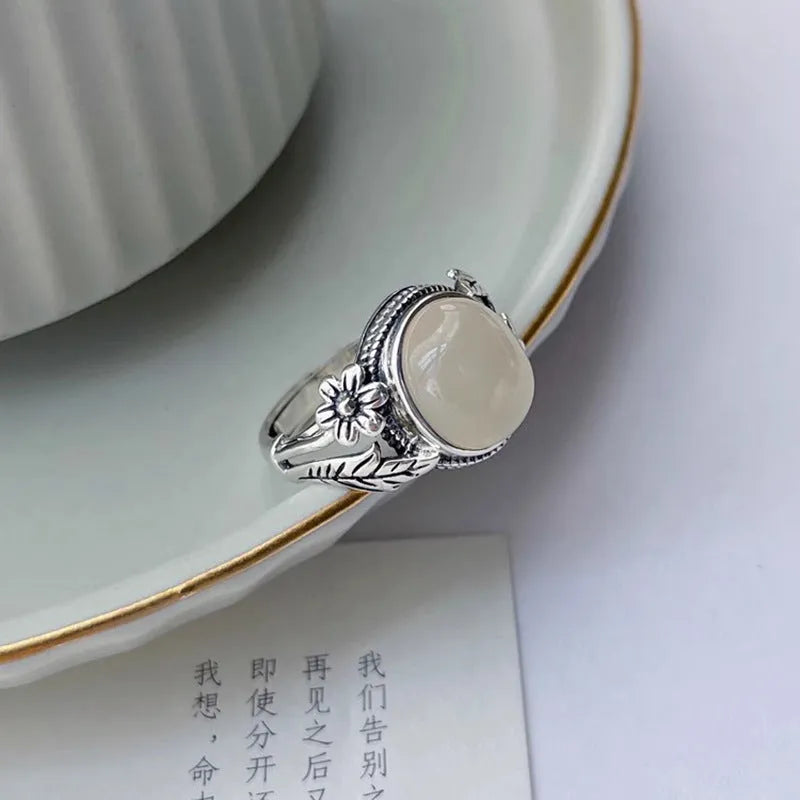 Antiqued copper ring with white stone and adjustable U-shaped opening.