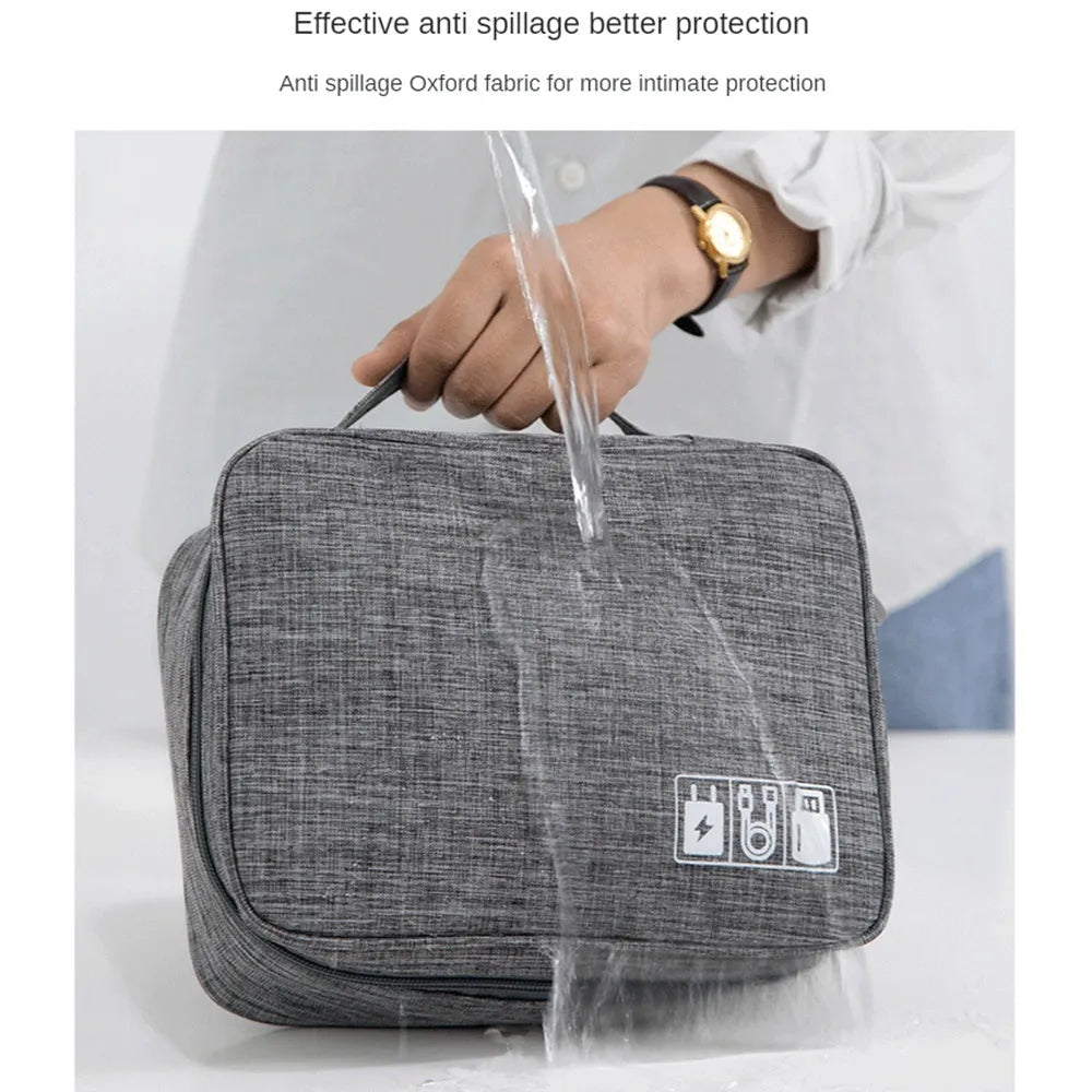 Black waterproof cable organizer bag open, showing removable dividers and mesh pockets for electronics.