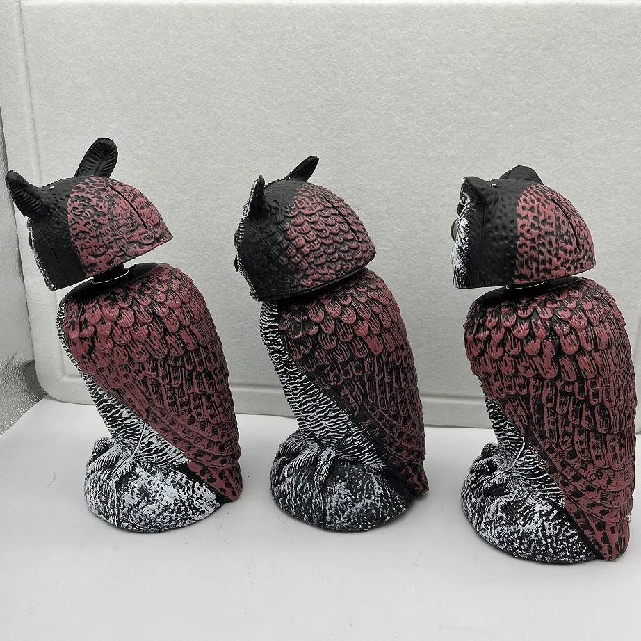 Polyethylene artificial owl bird scarer ornament with moving head, shown in a garden setting.
