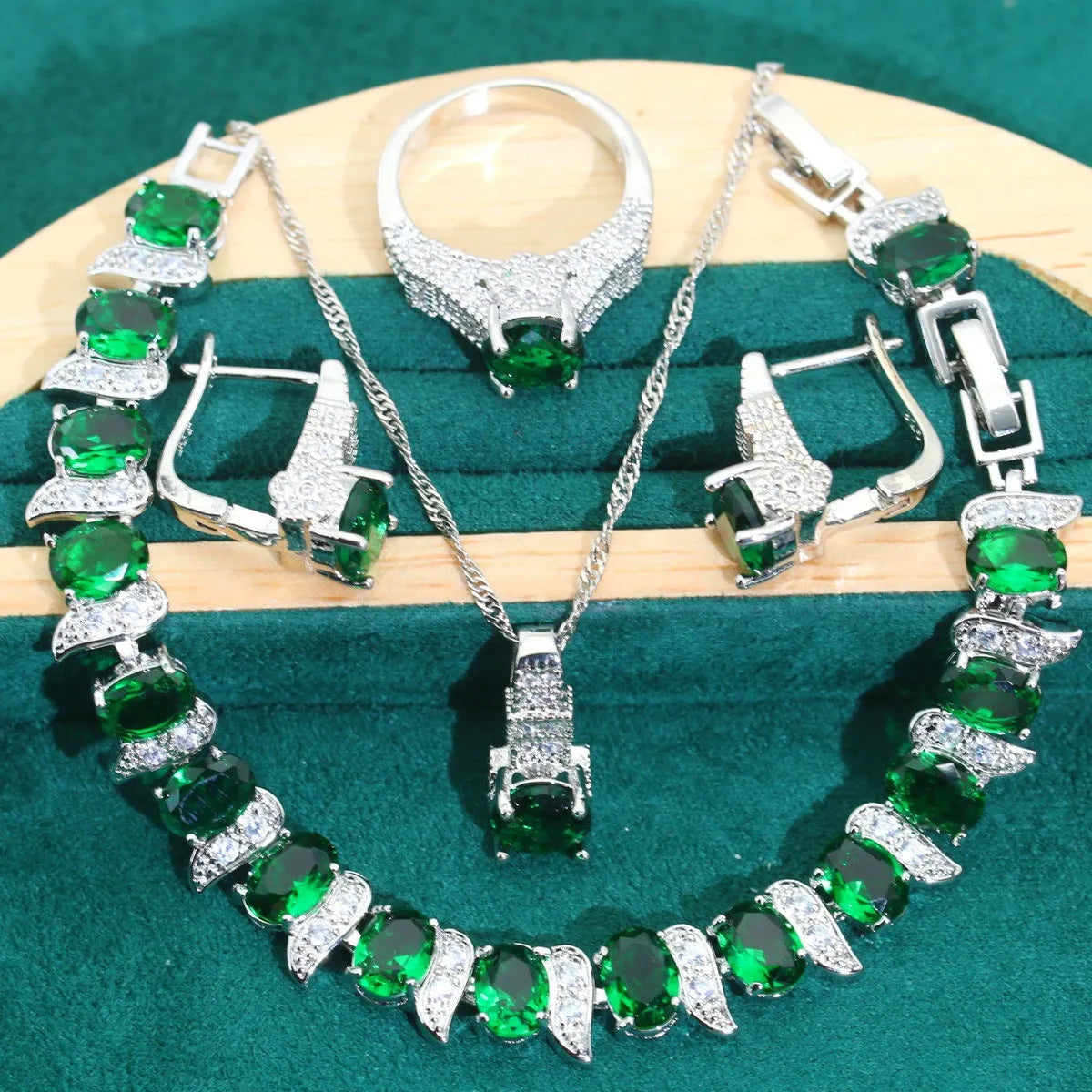 Four-piece bridal jewellery set showing alloy pendant necklace, bracelet, earrings, and ring on a white background.