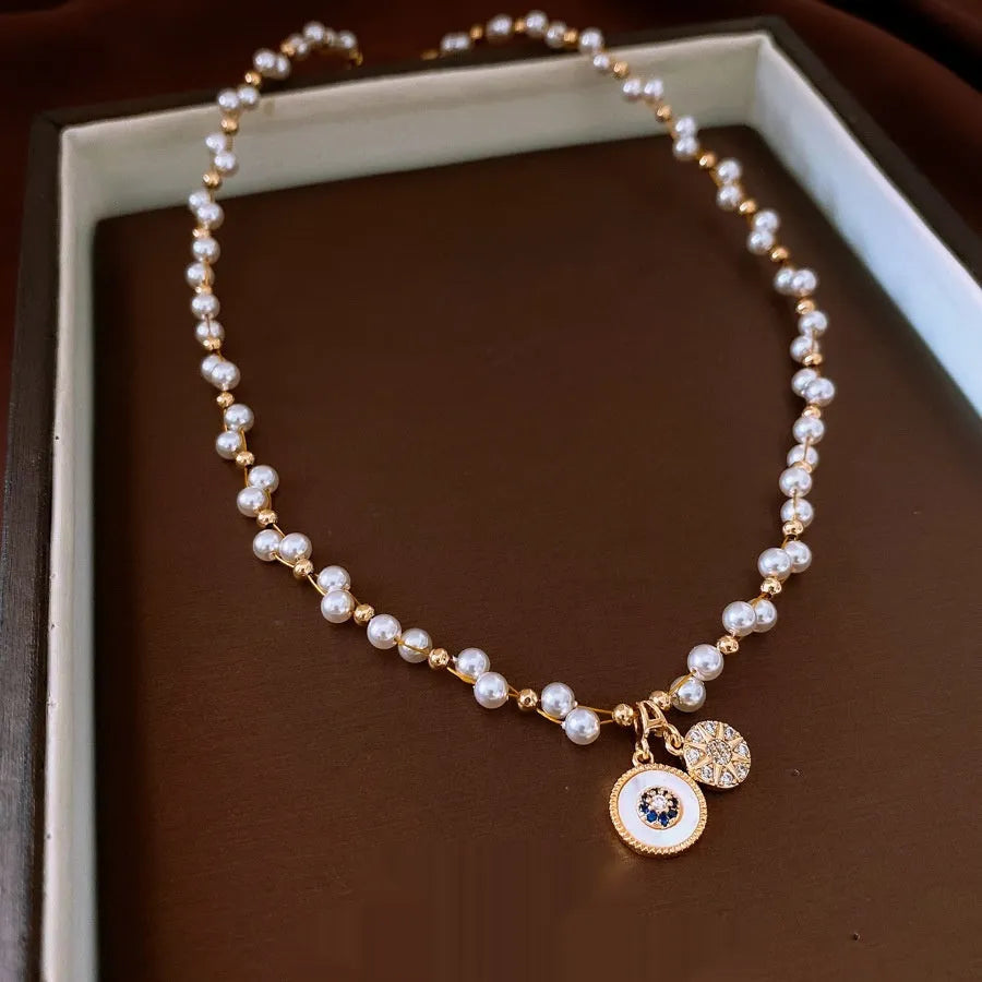 Gold electroplated round pendant necklace with inlaid zircon stone on a clavicle chain
