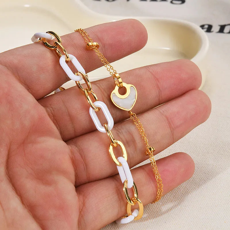Women's stainless steel bracelet with electroplated finish and a double-layered resin heart charm.