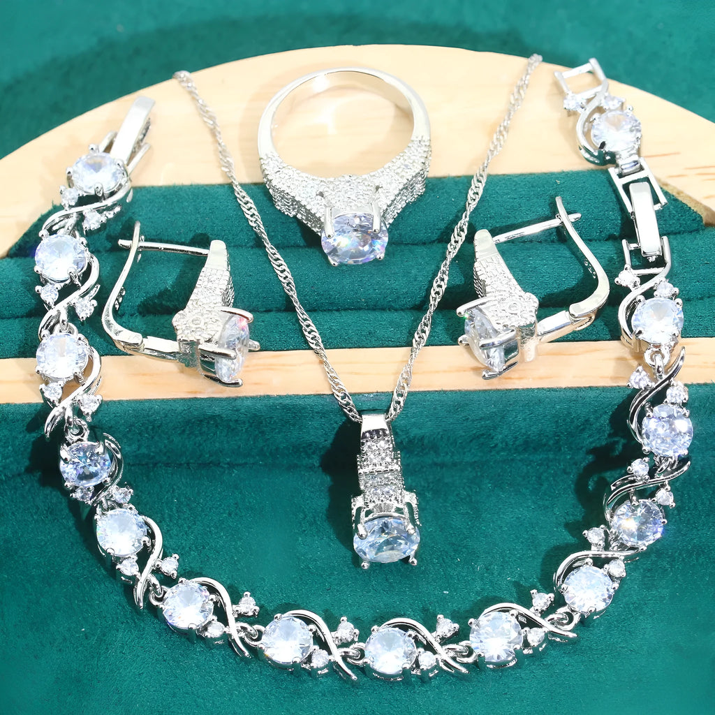 Four-piece bridal jewellery set showing alloy pendant necklace, bracelet, earrings, and ring on a white background.