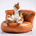 Small lazy cat resin model ornament with fabric art sofa on a car dashboard.