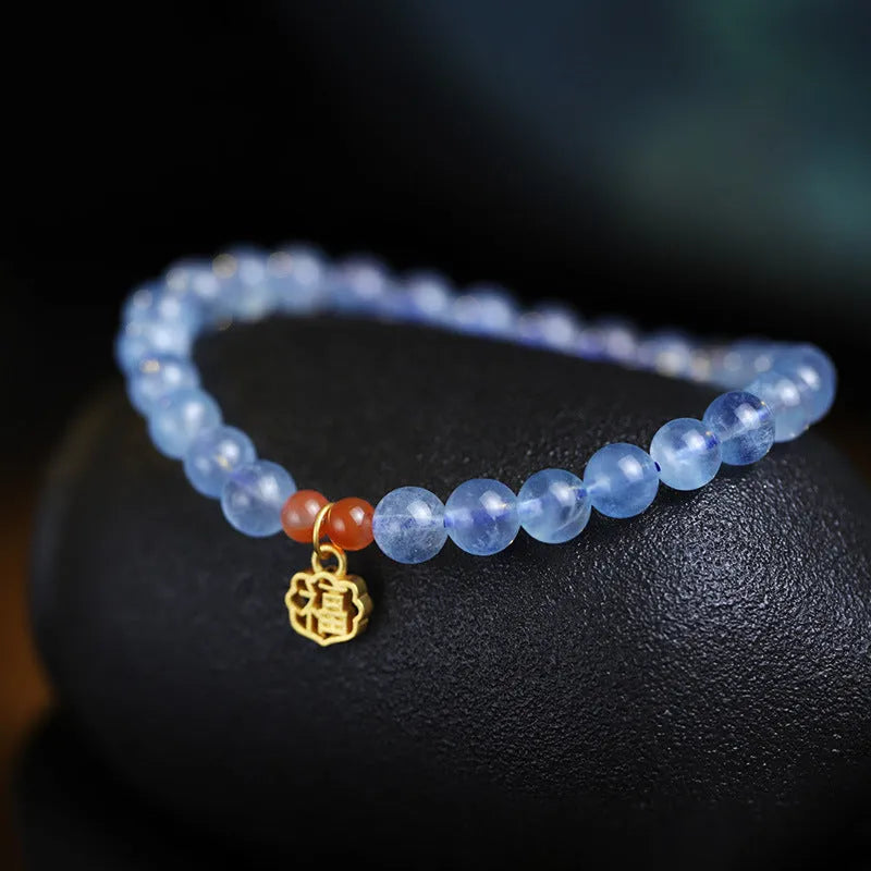 Women's crystal bracelet with ice translucent aquamarine 8mm round beads and sequin detailing on a white background.
