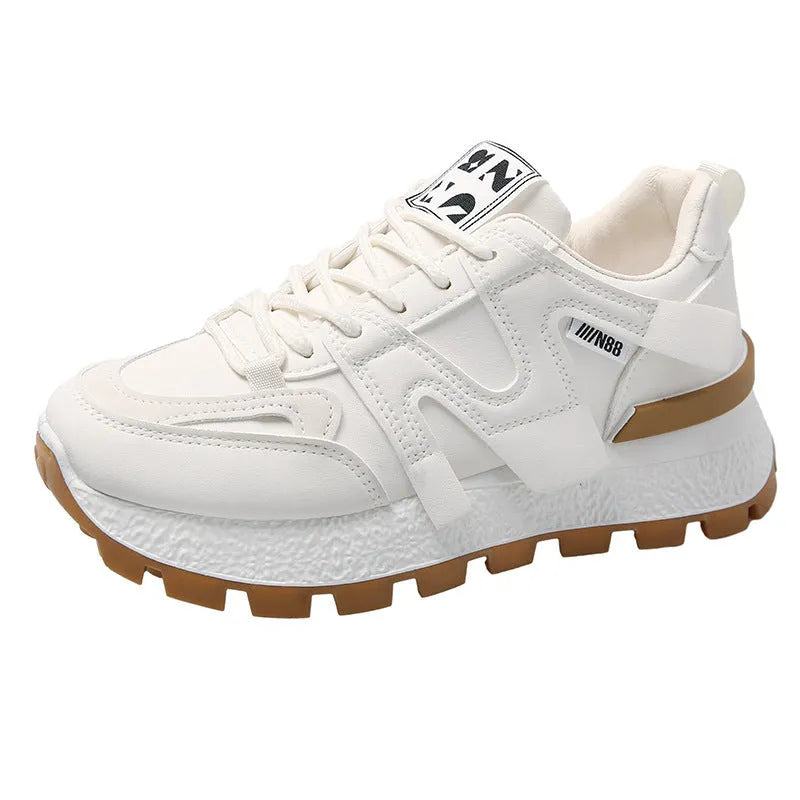 Low-top round-toe sneaker in black or white with lace-up front and flat rubber sole.