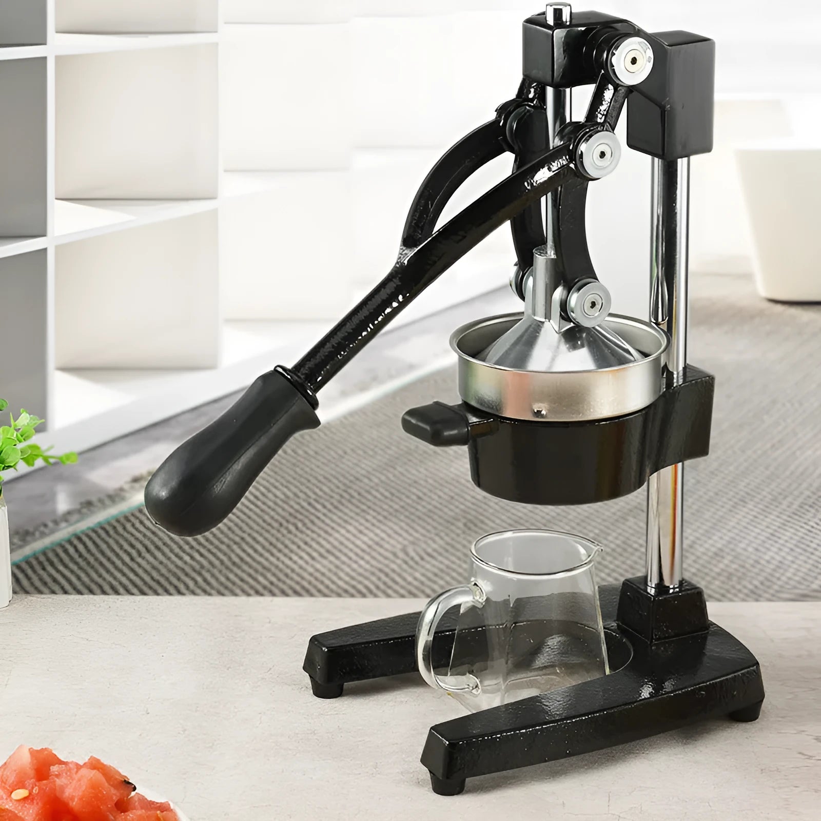 Black and white manual cast iron citrus juicer with stainless steel strainer, 40cm tall.