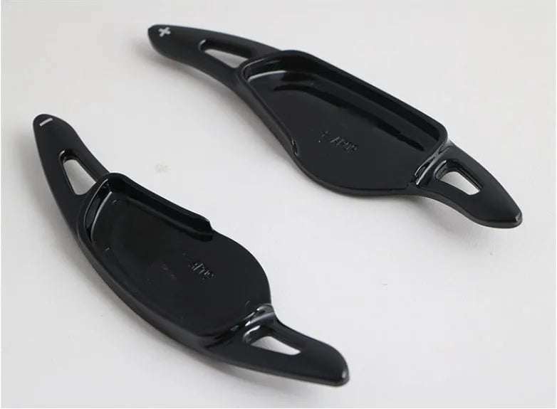 Steering wheel paddle shifter for car interior in various finishes including carbon fibre.