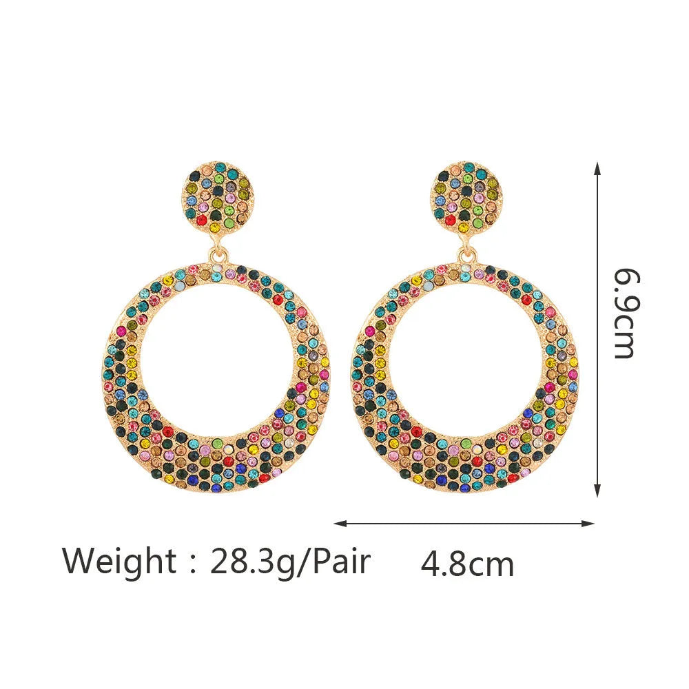 A pair of large, round, colour diamond-shaped cartoon-style metal pendant earrings on a white background.