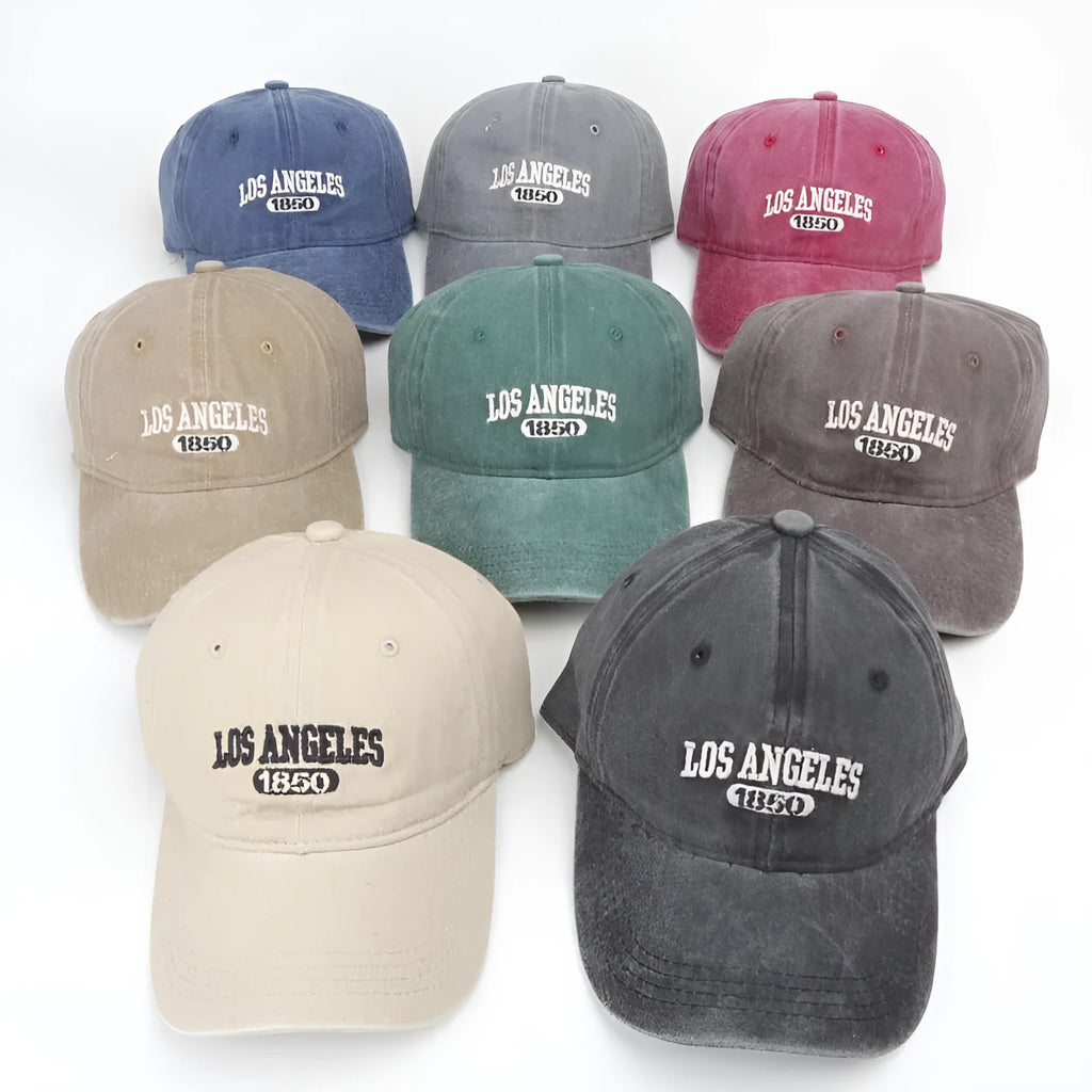 Retro style peaked cap with embroidered distressed letters on the front, shown in beige colour.