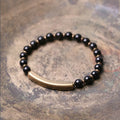 Layered multi-strand ethnic bracelet with natural stone beads and brass detailing on wrist
