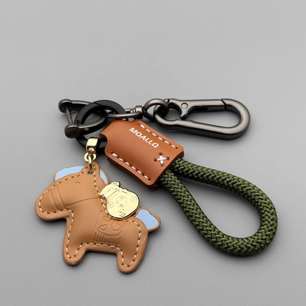 Handmade brown cowhide leather key ring with a gold-toned zinc alloy pony buckle and a green plaited flannelette rope.