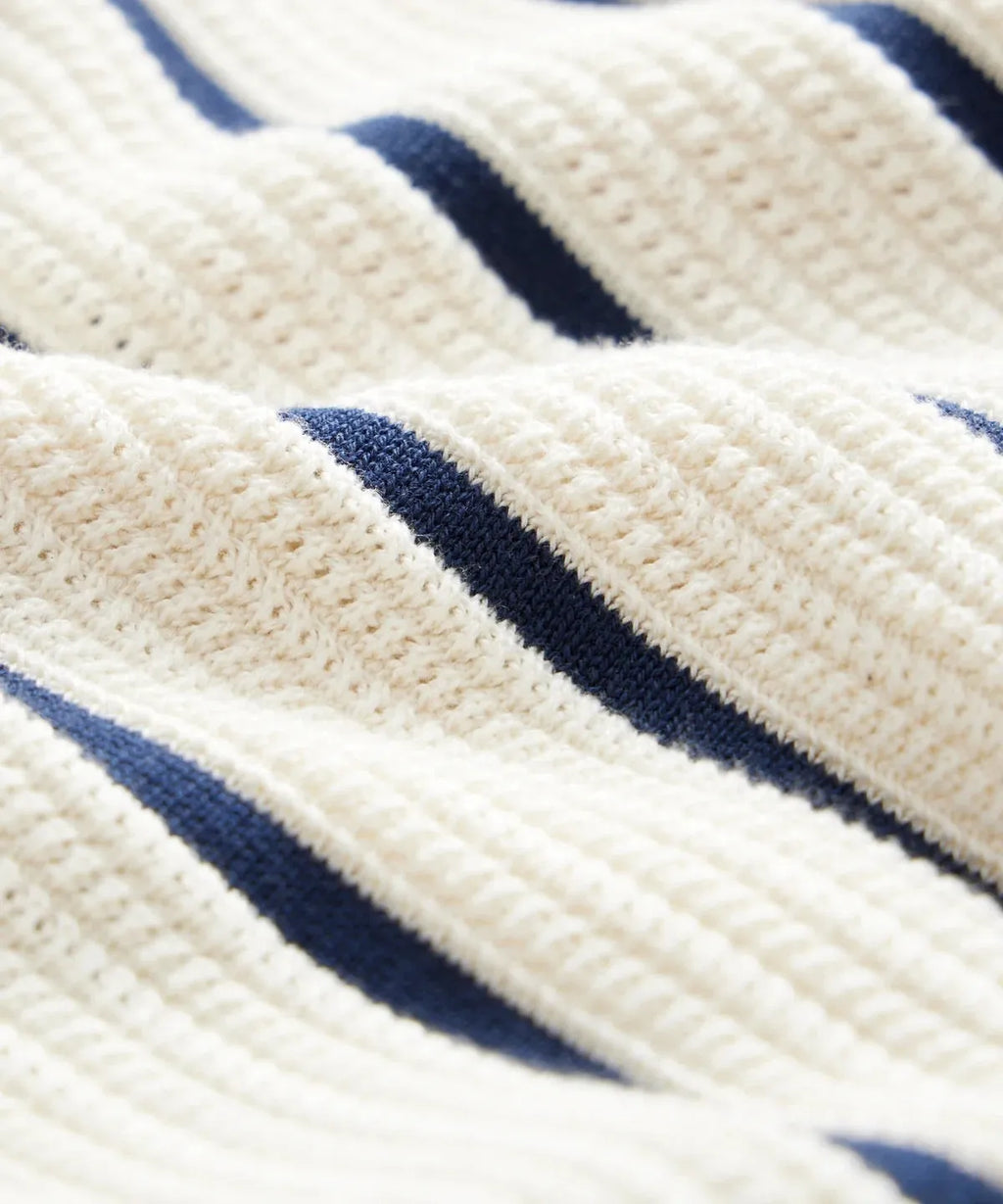 Men's white short sleeve knitted top with asymmetrical lapel collar and stripe pattern