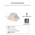 Beige wine bottle shaped camping lantern with USB-C port and adjustable light settings on a wooden table.