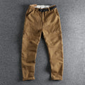 Men's khaki cotton work trousers with an N I buckle belt on a mid-rise waist.