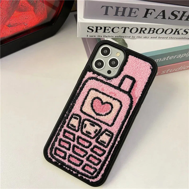 Pink iPhone case with a textured, towel-like embroidered design on the back.