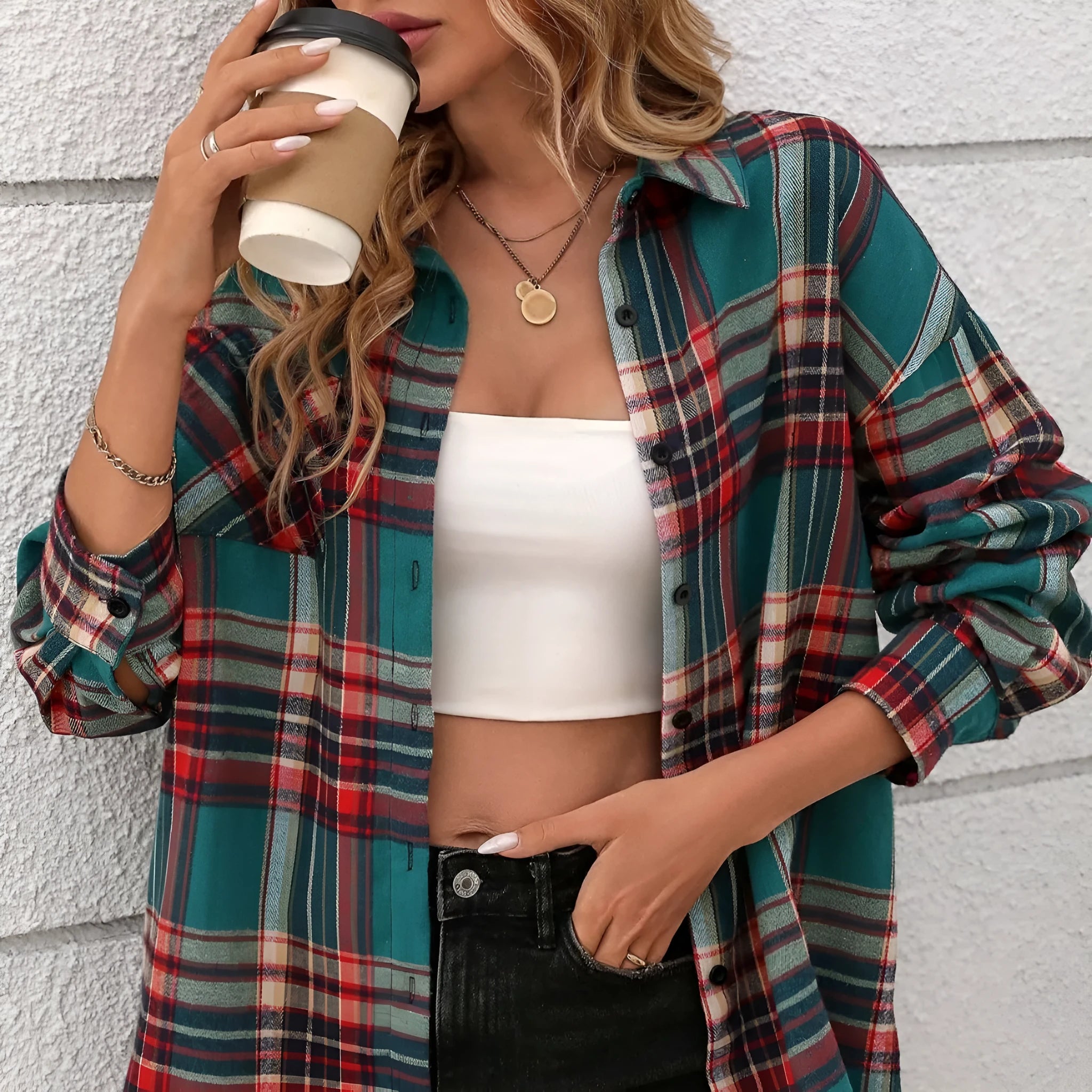 A woman's loose-fit long sleeve plaid shirt in a casual retro style, shown on a hanger.