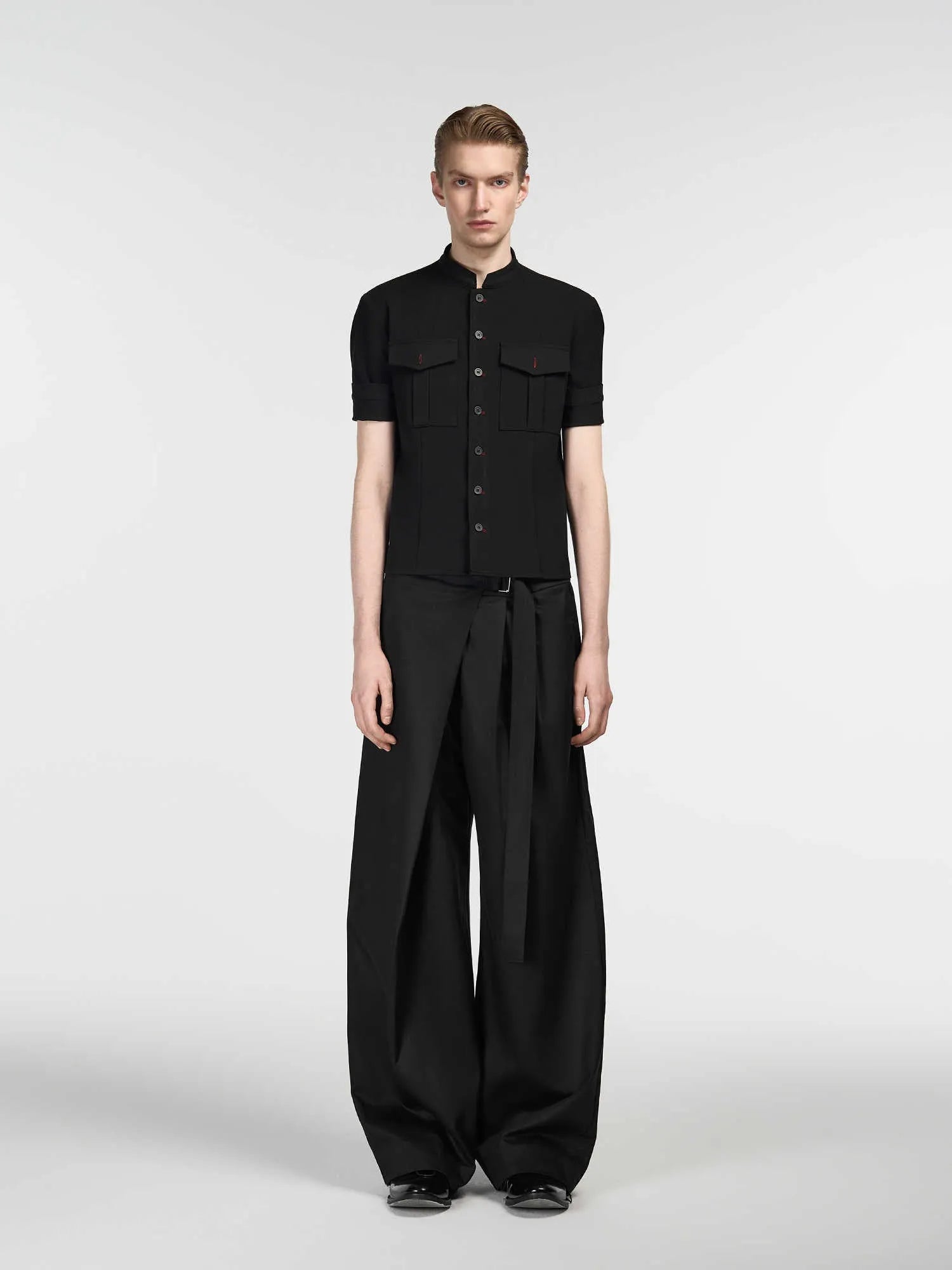 Black straight-leg trousers with a single pleat and adjustable waistband, laid flat.