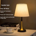 Retro alloy LED bedside lamp with speaker design and button controls on wooden table