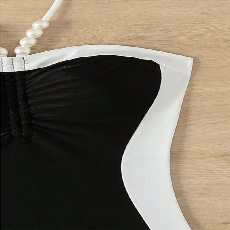 Black and white women's one-piece swimsuit with spaghetti straps and slimming cut