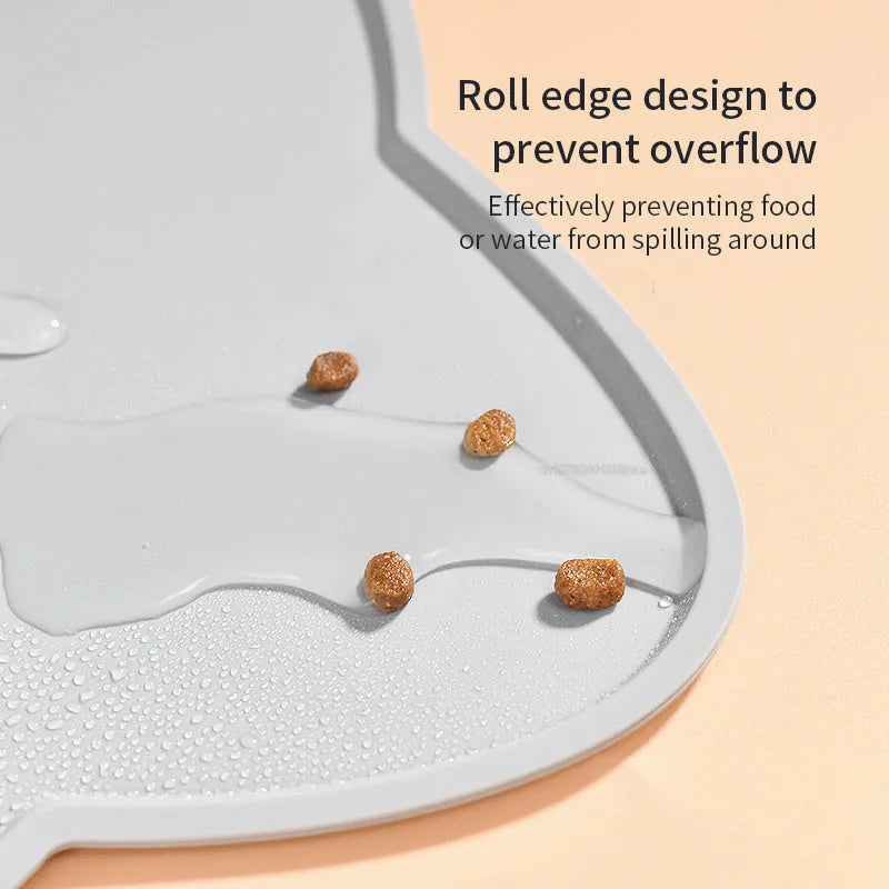 Blue silicone pet feeding mat with cat head shape under food and water bowls