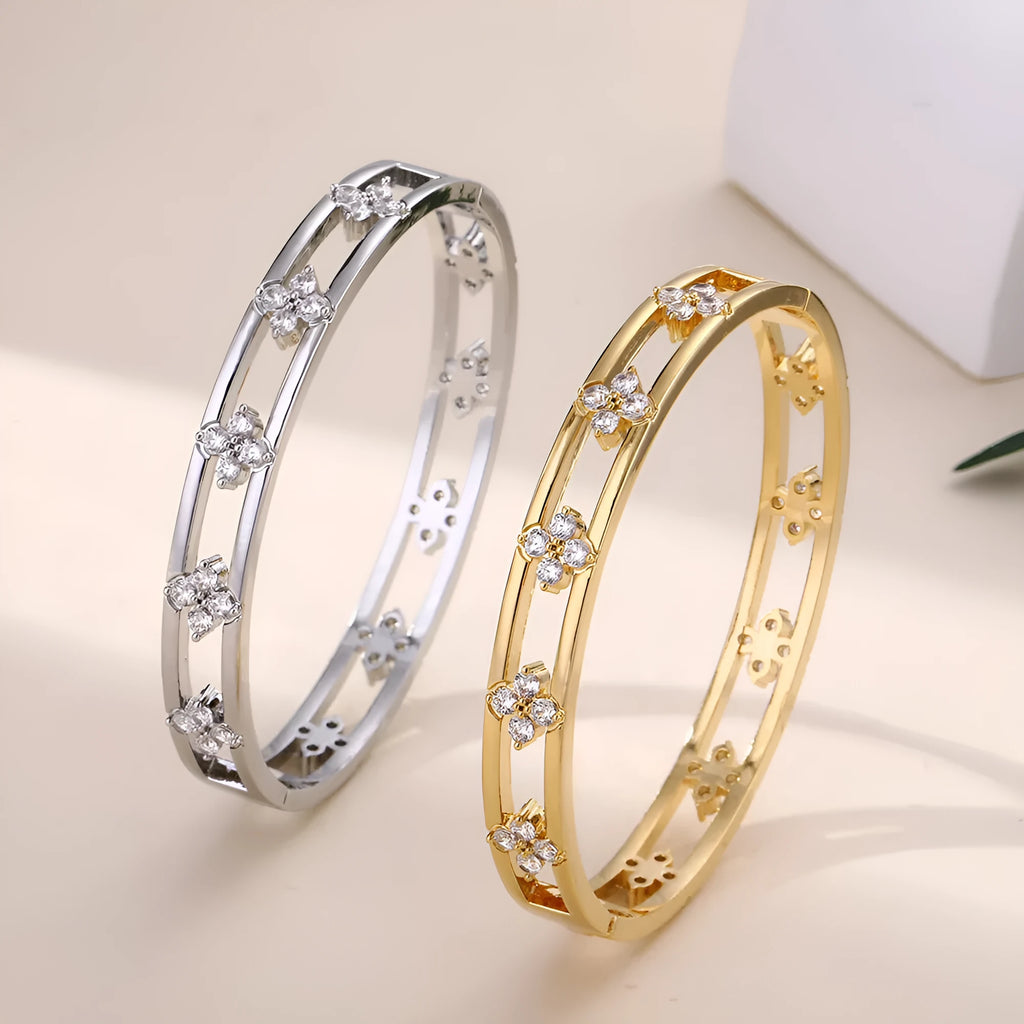 Women's hollow bracelet with a four-leaf clover zircon charm on an adjustable band, shown in gold and silver finishes.