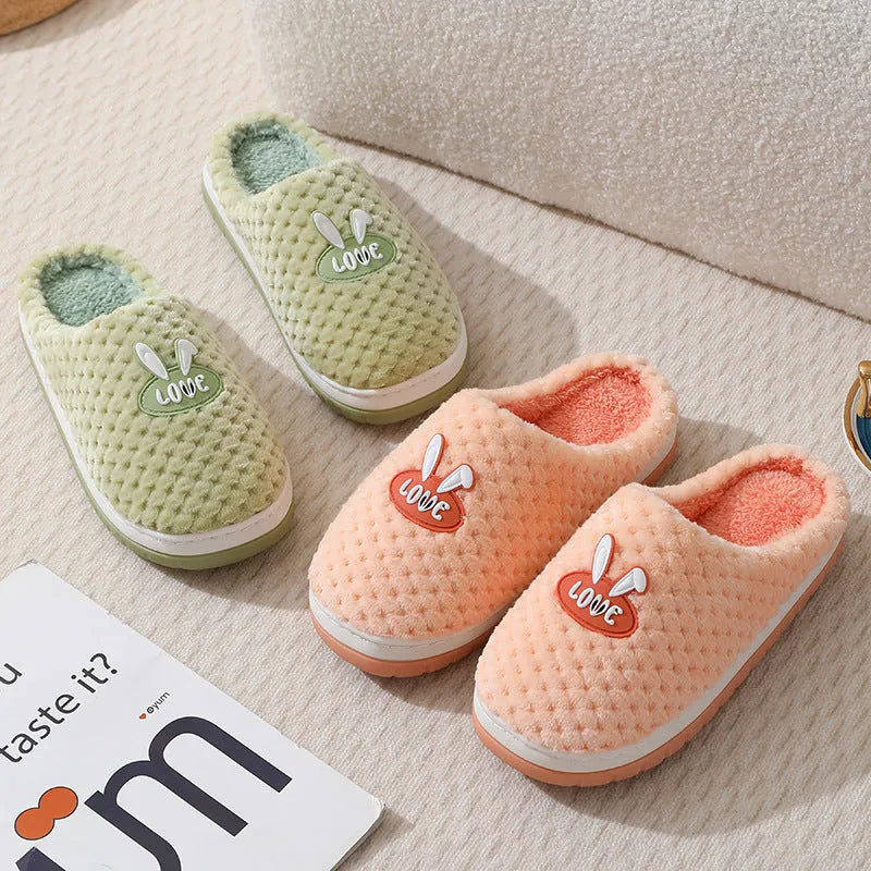 Women's plaid design artificial fur winter slippers with rubber sole on a wooden floor.
