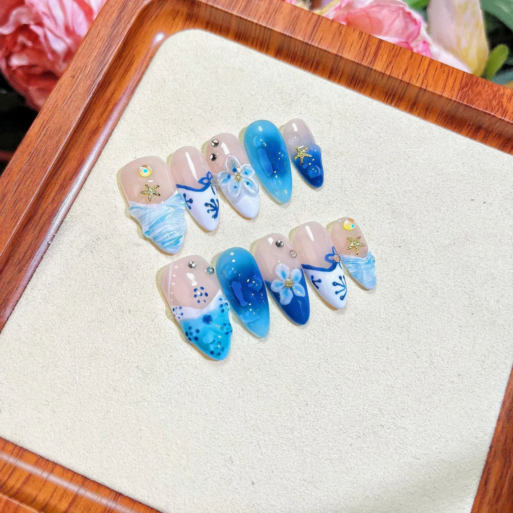 Set of blue hand-painted carved summer ice transparent plastic fake nails in sizes XS, S, M, L.