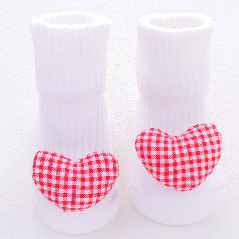 Cotton baby floor socks in a selection of colours and patterns like panda, lion, and bows, shown in sizes for infants.