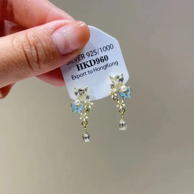 Geometric alloy ear clips with heart shape, rhinestone stars, and tassel details on a white background.