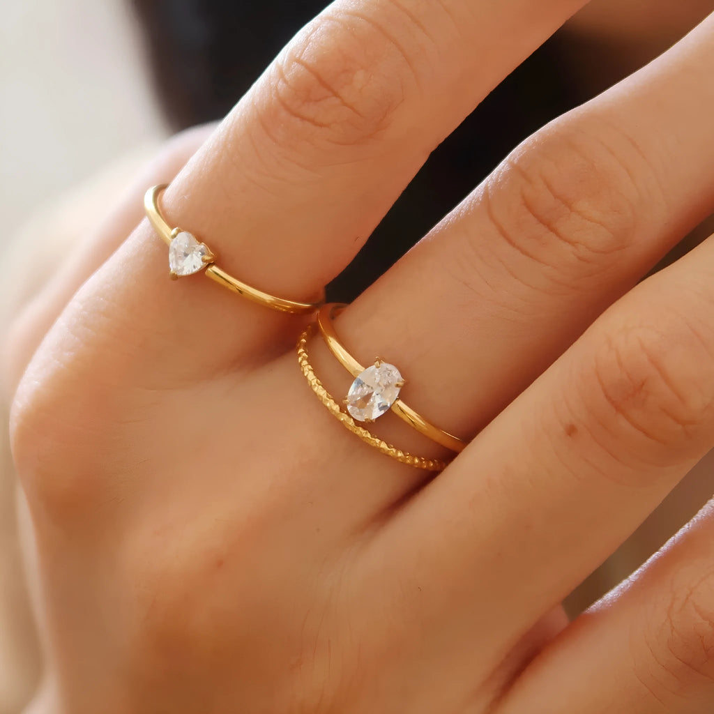 Golden stainless steel ring with love heart and oval designs showing electroplated finish and simple bracelet style