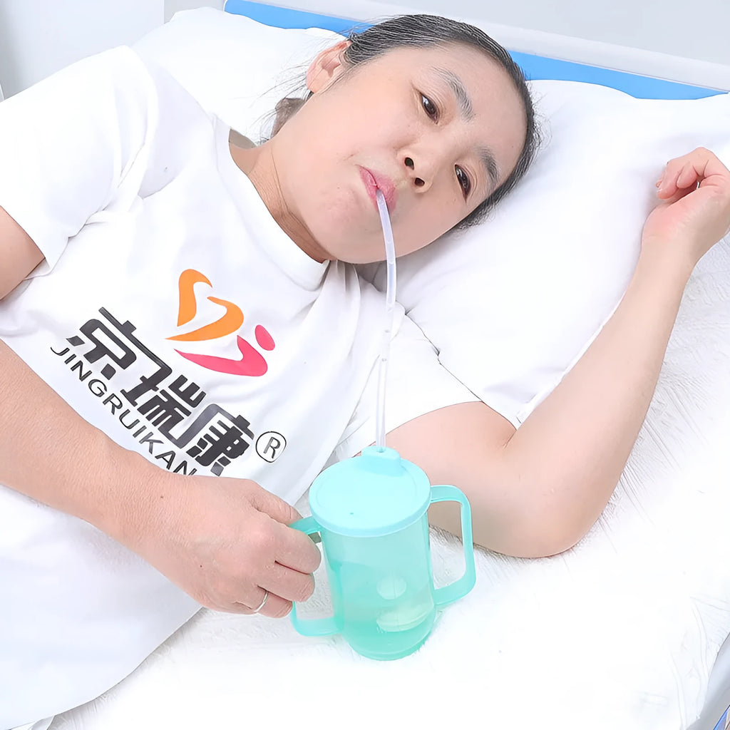 Oblique angled choke-proof drinking cup for elderly bed care with handle and optional wrist splint