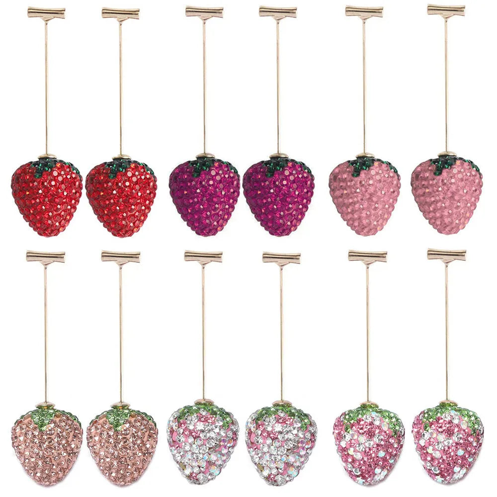 Close-up of geometric spot-drill strawberry stud earrings in red zinc alloy, shown on a plain background.
