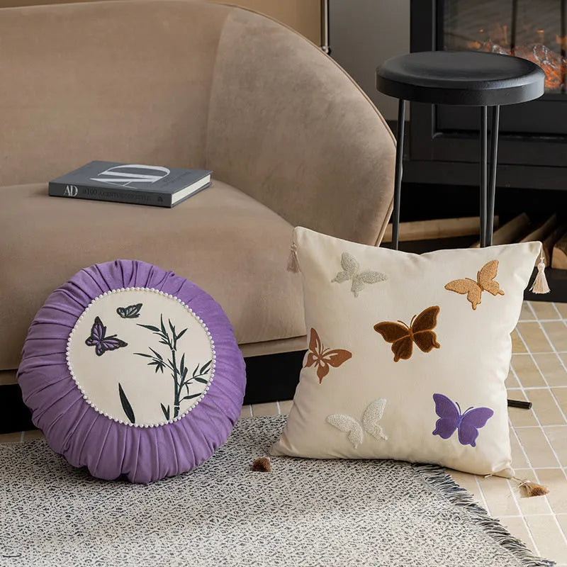 Square beige cushion with black butterfly embroidery in a Chinese style, 45cm by 45cm.