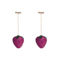 Close-up of geometric spot-drill strawberry stud earrings in red zinc alloy, shown on a plain background.