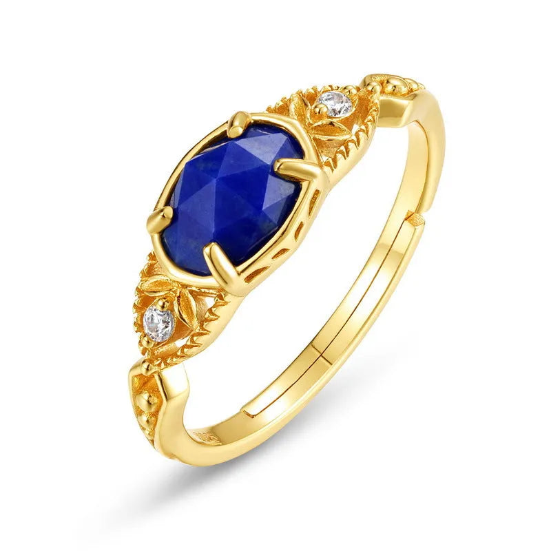 Silver geometric ring with an oval blue lapis lazuli stone on a model's finger.
