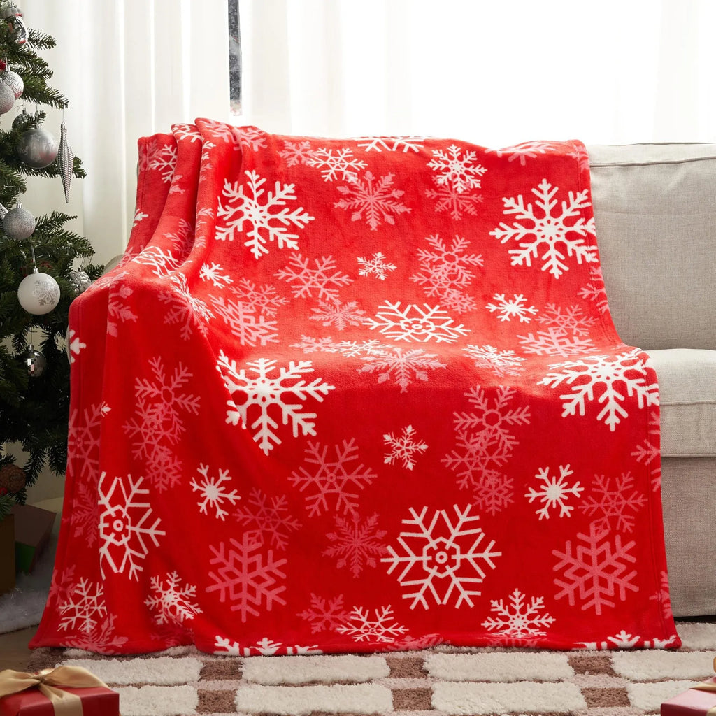 Soft flannel red Christmas blanket with plush texture on a sofa, showing reversible design and size scale.