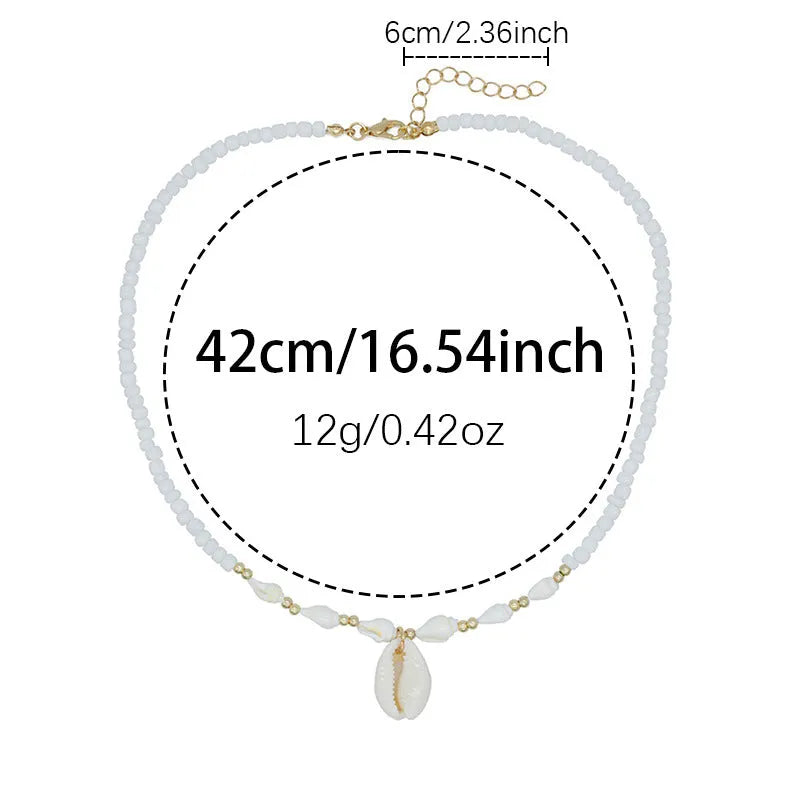 White necklace with a mother of pearl conch shell pendant and beads on an electroplated chain.