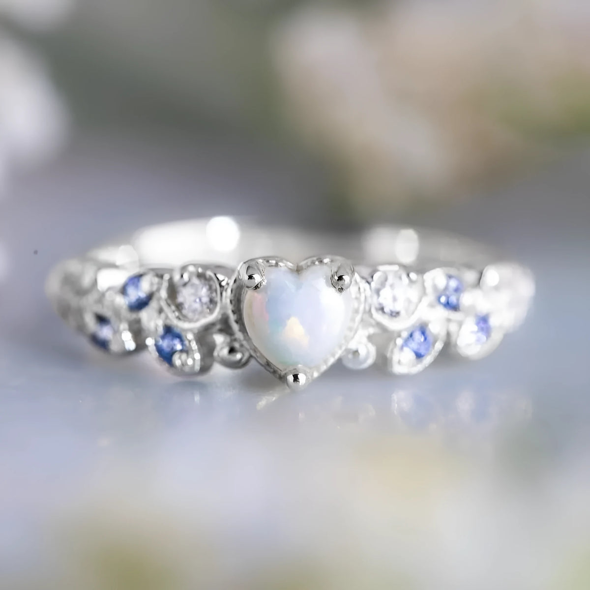 Women's white alloy heart ring with flower opal ocean design shown in UK size 10