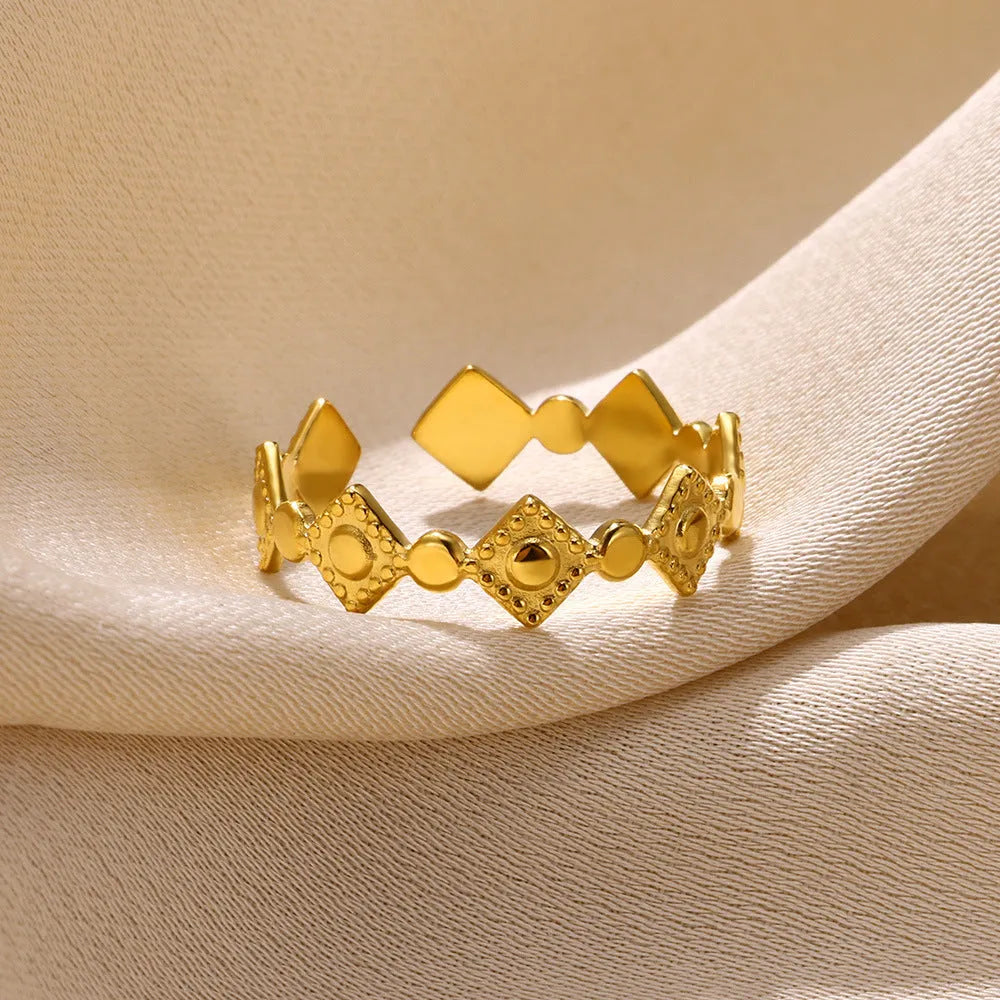 Geometric titanium steel women's ring with gold diamond finish shown on hand